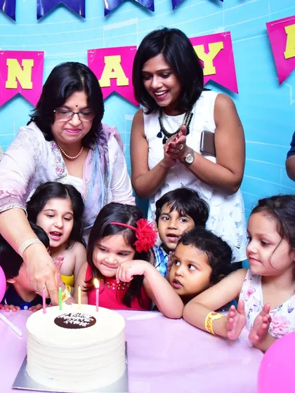 A birthday cake cutting ceremony filled with excitement and anticipation from all the young guests.
