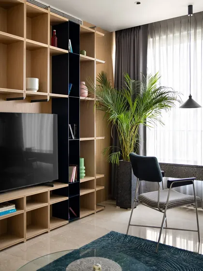 The full view of the media and shelving wall in the multipurpose room. The design provides ample storage and display space while maintaining a clean, uncluttered aesthetic.