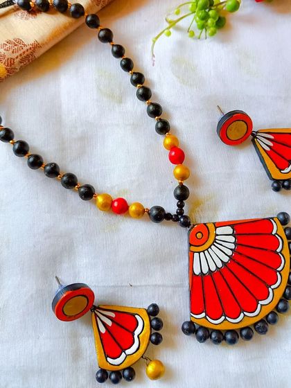 The same fan-shaped pendant necklace, here in a classic red and white combination.