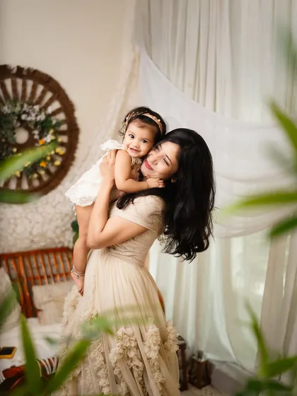 A mother and daughter share a sweet cuddle. The soft, natural lighting and the genuine affection make this a truly heartwarming portrait.
