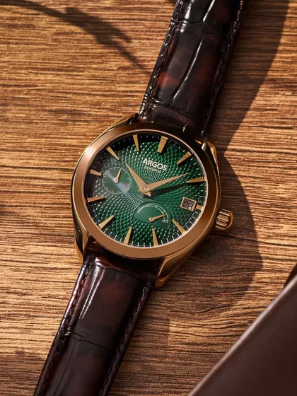 Context is everything. Placing this green-dialed Argos watch in a lifestyle setting with leather goods and a wooden surface tells a story of sophistication. The lighting is designed to feel natural, like a sunbeam hitting a desk, making the product feel accessible yet aspirational.