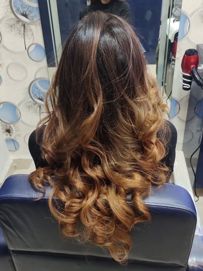 The perfect finish for a balayage. These bouncy curls show off the beautiful blend of warm brown and caramel tones, creating a voluminous and glamorous style.