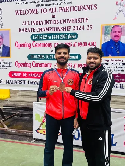 Tushar with his bronze medal from the All India Inter University Games, posing with his coach.