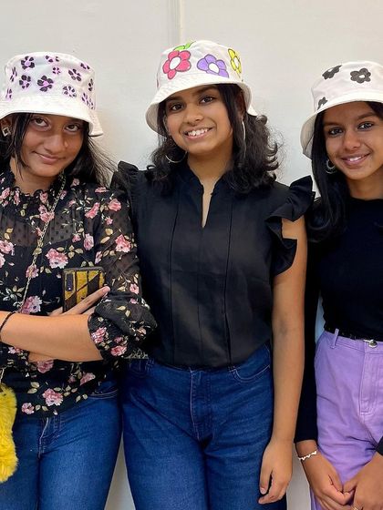 Three friends, three unique floral designs. This photo showcases the variety of creations from our bucket hat painting party.