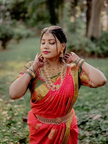 A candid moment during an engagement shoot. The focus is on the bride's joy and the beauty of her traditional attire, captured in a natural, outdoor setting.