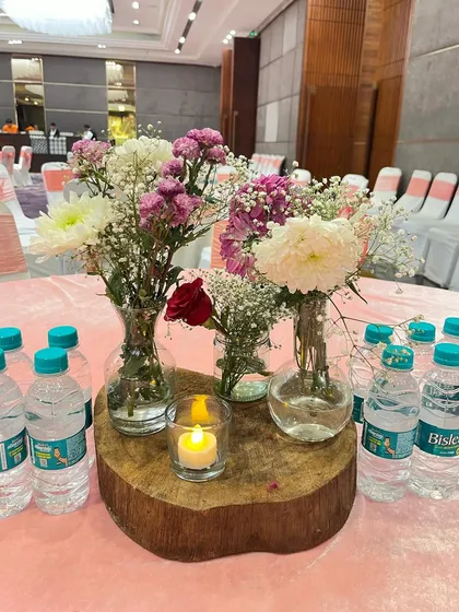 Another angle of the rustic wood slice centerpiece, showing the mix of different flowers and a small candle.