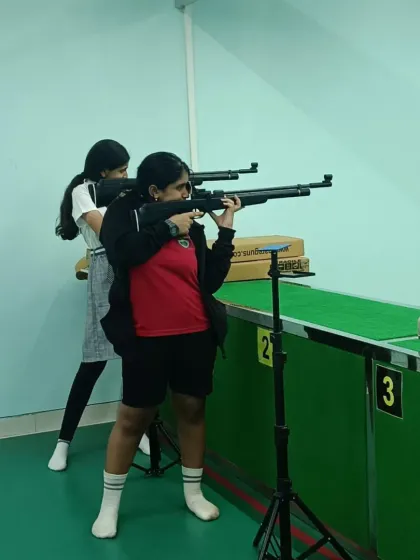 An instructor provides hands on assistance to a student from Greenwoods High, adjusting her stance for better stability and accuracy. This personalized coaching is a key part of our school sports exposure programs.