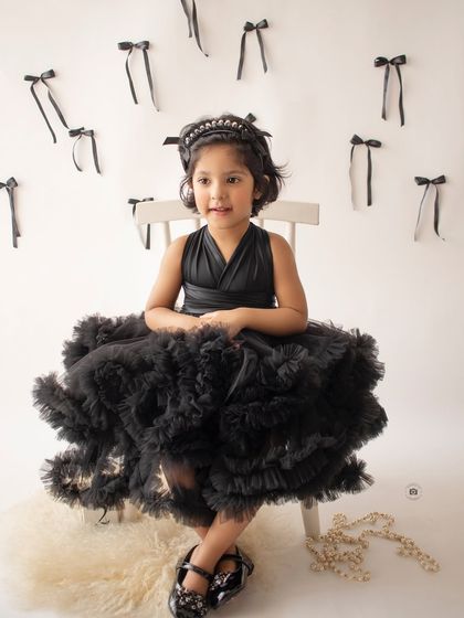 A full-body shot showcasing the gorgeous black tulle dress. This classic portrait has a touch of high-fashion flair.