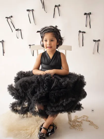A full-body shot showcasing the gorgeous black tulle dress. This classic portrait has a touch of high-fashion flair.