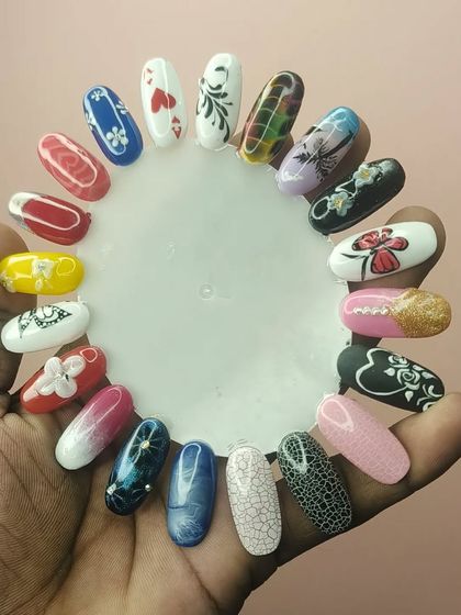 A student proudly displays some of their practice work, showing a variety of techniques including marbling, floral art, and gradients.