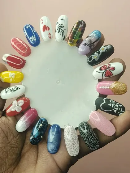 A student proudly displays some of their practice work, showing a variety of techniques including marbling, floral art, and gradients.