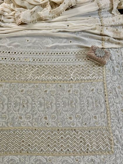 A full flat-lay of the saree, showing the different panels of embroidery and the overall design.