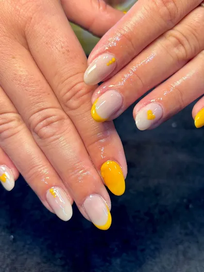 Inspired by the king of fruits, these mango-themed nails are perfect for summer. The design features sunny yellow tips and solid accent nails with tiny heart details.
