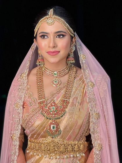 A classic portrait showing the bride's full face and jewelry. The makeup is precise and elegant, perfect for a timeless bridal look.