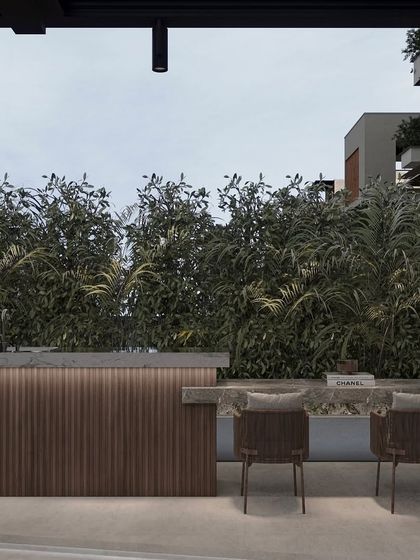 This custom outdoor bar is a perfect example of our attention to detail. The design features a ribbed wood front, a sleek stone countertop, and integrated lighting, all set against a dense wall of green hedges for privacy and ambiance.