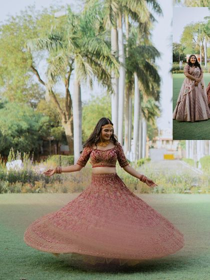 A bride twirls joyfully in her lehenga on a lush green lawn lined with palm trees.