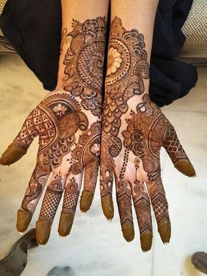 A full and intricate design for the palms, featuring a mix of peacock and floral motifs with a beautiful dark stain.