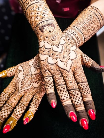 A stunning engagement henna design with a central mandala on the palm and intricate work on the fingers.