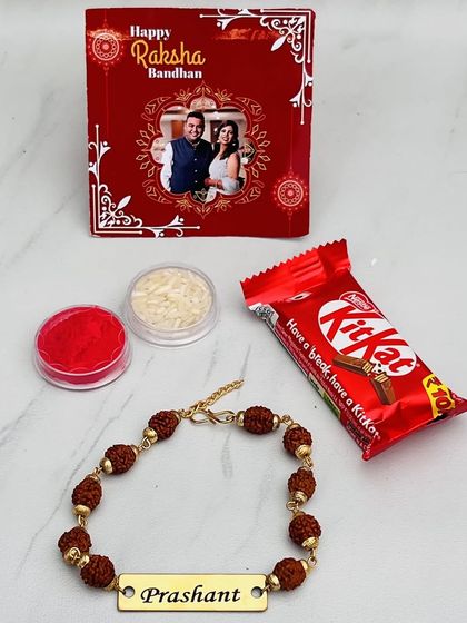 Our mini Rakhi hamper is a perfect small gift. It includes a metal Rudraksha rakhi with a custom name, a personalized photo card, and a KitKat chocolate.
