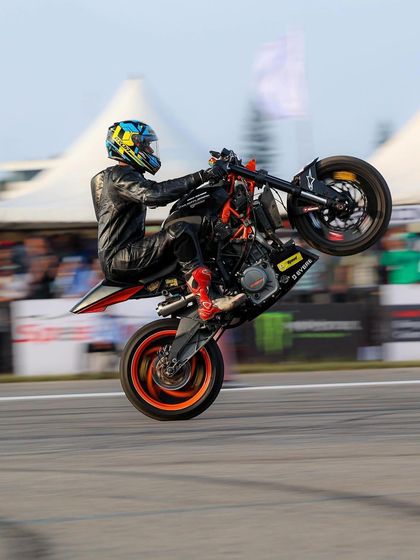 A rider on a KTM Duke performs a high-speed wheelie. The combination of speed and technical skill is what makes stunt riding so exciting to watch.