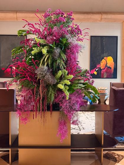 This arrangement sits elegantly on a modern console, blending vibrant pinks and greens with the sophisticated art and decor of the hotel lounge. My work is always designed in conversation with its surroundings.