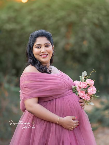 A lovely close-up portrait taken during golden hour, highlighting the mother's radiant smile and the soft colors of her gown.
