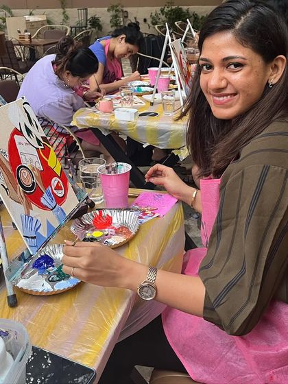 A participant focused on her chic coffee themed painting. The cafe setting is the perfect backdrop for this kind of artwork.