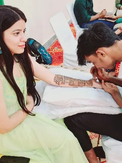 My team and I are experienced in handling mehandi for the entire wedding party. Here, one of my 25 professional artists is applying a beautiful design for a guest, ensuring everyone feels included in the celebration without long waits.