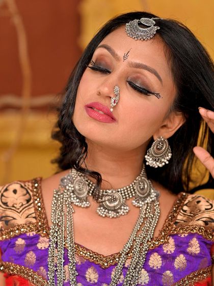 A playful and emotive shot from the Rajasthani folk set. The model's pose and expression, combined with the themed props, help build a narrative within the single frame.