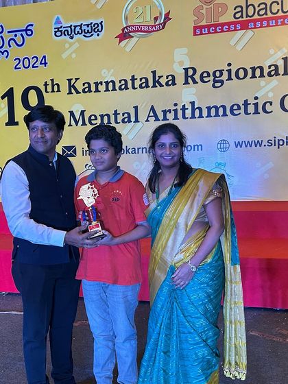 A family moment on stage as a student receives his award. The support of parents is crucial, and we love to celebrate with them.