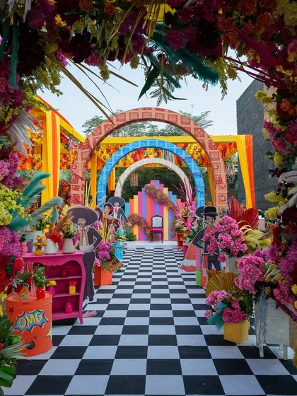 A grand, floral-lined entranceway for the "Vibrant Blooms" carnival, leading guests through a tunnel of color and excitement.
