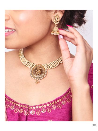 This close-up shows a traditional temple jewellery necklace and jhumka set, adding a touch of divine elegance to the silk blouse. It’s a perfect example of classic South Asian style.