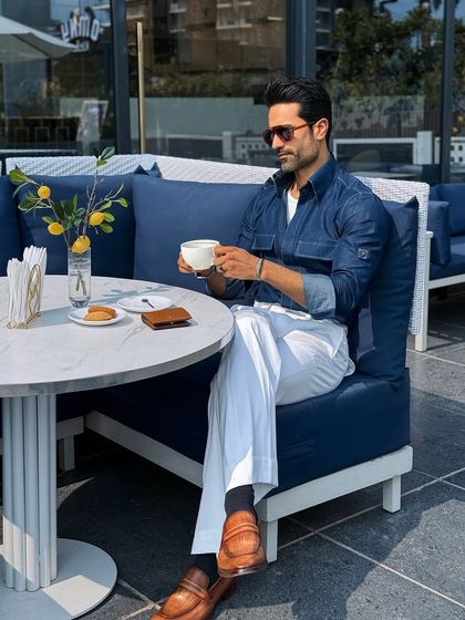 Enjoying a coffee at a luxury cafe, this image shows the versatility of our denim shirt. It’s a stylish choice for an effortless weekend date or a casual meeting.