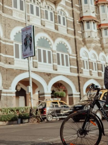 An elegant pose in front of the Taj Mahal Palace Hotel. The combination of a beautiful gown, a simple prop like a bicycle, and the grand hotel creates a chic, editorial-style photo.