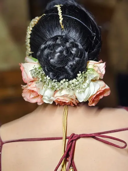 Another view of the intricate floral bun. We use real flowers to add a touch of freshness and elegance to the bridal hairstyle.