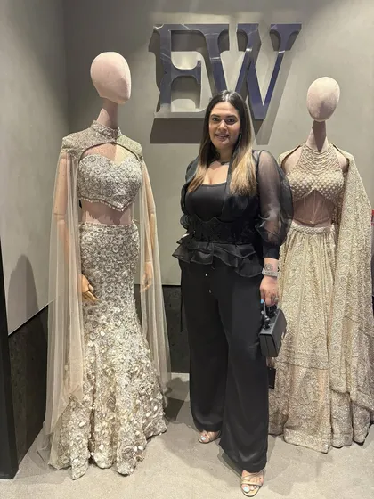 At the new Elisha Wadhwani store opening, standing next to her incredible couture creations. I wore her ultra-feminine ruffled black top to support the designer and showcase her detailed work.