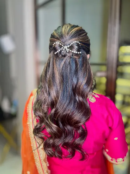 A view of the beautiful, simple hairstyle with a pearl accessory.
