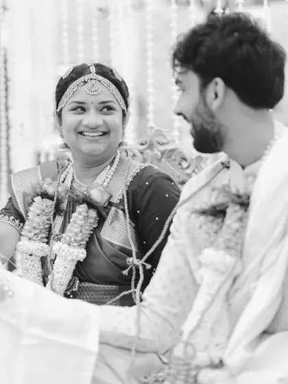 A quiet moment of connection between the bride and groom during their South Indian wedding ceremony. The black and white edit emphasizes their smiles and the unspoken conversation between them.