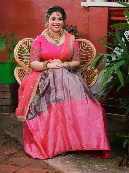 A seated portrait on a wicker chair, surrounded by greenery. The setting is relaxed and natural, complementing the bride's happy expression.