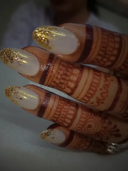 A classic bridal look with a modern twist. These almond-shaped nails feature a milky white base with a cascade of gold foil at the tips, designed to complement traditional wedding attire.