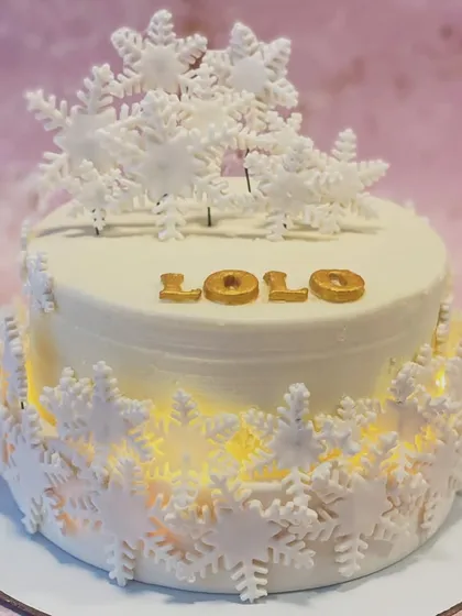 A closer view of the illuminated snowflake cake, showing the delicate sugar work.