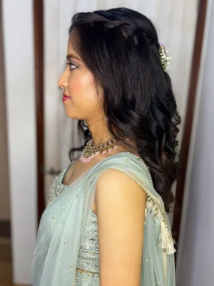 A side profile showing the half-up hairstyle with a simple braid and soft curls.