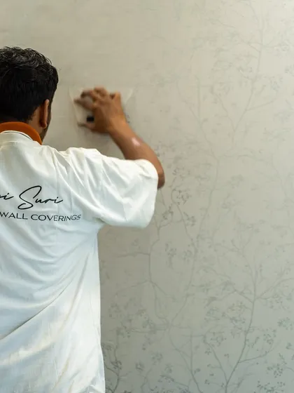 A member of the Shivangi Suri Luxury Wall Coverings team smoothing out a wallpaper panel. We ensure a flawless, bubble-free application for a truly professional and high-end finish.