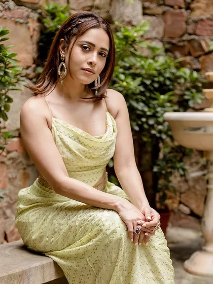 This lime green draped outfit by Punit Balanani on Nushrratt Bharuccha is perfect for a destination wedding. The cowl top and draped skirt create a chic, resort-style ethnic look.