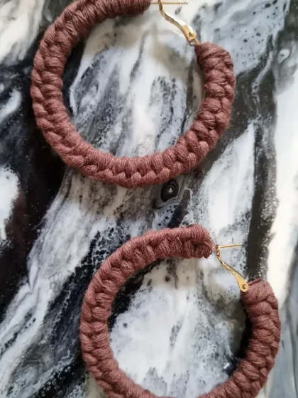 An earthy brown pair of macrame hoop earrings. The rich, natural color is versatile and perfect for a subtle, grounded style.