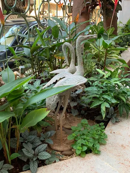 Another angle of the crane sculptures, showing how they integrate seamlessly with the surrounding plants and hardscaping.