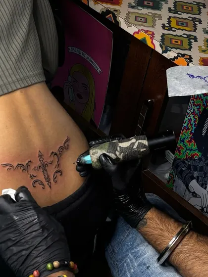 Inking a lower back tattoo. You can see the stencil and my setup in the background, showing the creative and professional environment of the studio.