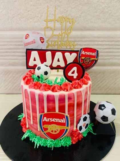 An Arsenal FC cake with a red and white drip design, perfect for a 4th birthday celebration for a future football star.