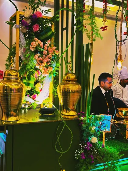 Detail shot of the decor on our green and gold buffet, featuring large golden urns and intricate floral work. These elements contribute to the premium, bespoke feel of our catering service.