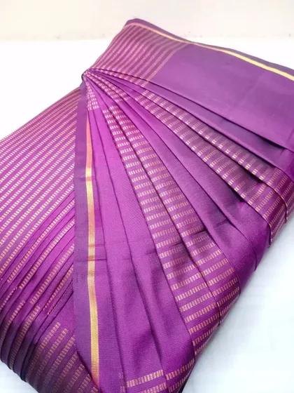 A purple silk saree with fine gold stripes, pleated and ready for a special occasion.